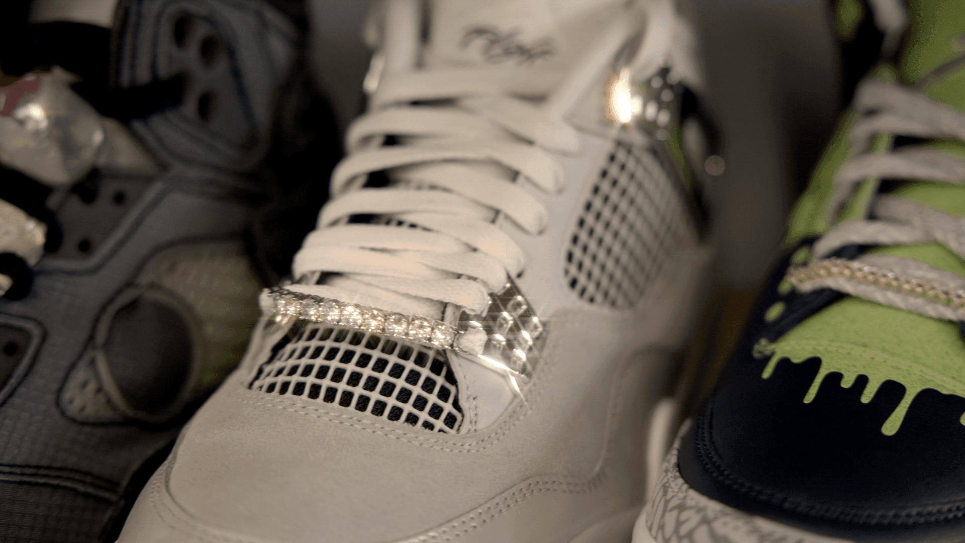 Close-up of three sneakers with unique designs and textures, featuring gemstones and colorful patterns.